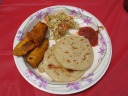 A pork-and-cheese papusa, a cheese-and-beans papusa, some fried
plantains, a little `slaw, and some red salsa.
