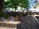 Johnson's Burying Ground.  Some of the earliest gravestones are bare due
to the Puritan prohibition of images.  Many later gravestones included
winged skulls, as seen up close on the tombstone at right, and as seen
in smaller versions (view the full-sized image) on the tombstones at
left.
