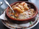 "Gambas al Ajillo - garlic shrimp."  One of the stars of the meal.  We
smelled the dish as it approached our table.  Delivered still bubbling
in a hot dish, the dish was "terrific," receiving comments like "Oh my
... oh my ... oh my" and "wow."  Look at all the garlic in the picture! 
After finishing the shrimp, we soaked up garlicky juices with bread.  If
I recall correctly, my mom was double-fisting her sauces--she had bread
in both hands as she dipped and ate.  (Note: I don't remember if both
dippings were for the garlic sauce or if only one was and one was going
to another sauce.)
