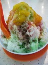 Mango ice kachang.  Ice kachang is a dessert of shaved ice, flavored
with fruit syrups, atop red beans, corn, strange green jelly sticks
(which I think were "agar agar", a jelly made from seaweed), red jelly
squares (which I think were "grass jelly"), and clear chewy ovoids
(which I think were "attap chee", basically palm seeds).  For my mango
ice kachang, the shaved ice had cubed mangoes and pineapples and was
topped with mango juice.
