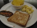 Eggs tossed with boiled potatoes.  (Yes, boiled potatoes.  No, I don't
know why they didn't saute or stir-fry them.)  Accompanied by pineapple
slices and toast.  As for the item at left, I took it thinking it was a
large barbecued shrimp.  It turned out to be a mild white-fleshed fish
with chunky meat.
