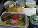 From top-to-bottom, left-to-right:

 fresh fruit (including dragon fruit once again, just like on the way to Singapore)

 croissant

 the rectangular container which held the breakfast I selected:
omelette with ricotta and red peppers, hash brown potato, sliced pork,
a grilled tomato, and somewhat creamy mushrooms.
