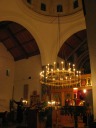 The atmospheric interior of the church as seen during the nighttime
choral performance.  The singers were in transept to the right. 
Incidentally, the murals are designed and painted by one of the monks.

