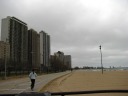 Looking north along the Gold Coast shoreline from near Oak Street Beach, 
one can see many tall apartment buildings overlooking the lake, crashing 
waves, and a crazy jogger.

