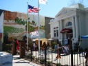 The old, classical-revival library, now the Chamber of Commerce.  A
number of costumed people, supposedly an actors guild, mostly not in
this picture, hung out in the open space out front.  I mainly took the
photograph for the mural and the building.
