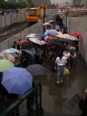 The sudden rainstorm caused flooding on this pedestrian walkway, one of
the few that crossed this major road.  Luckily, construction debris
(cement block, wood plank) helped people cross.  Look at all the
umbrellas.

