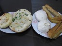 From left to right, a sugary layered pancake, a green oil leavened bread 
pancake, a steamed bun filled with shredded turnip (oily, so much so it 
seeped into the dough), a steamed bun filled with spicy, moist meat, and 
a Chinese donut.  Because I went out to buy breakfast with Di Yin, I 
watched the guy roll the dough and make the doughnut.

