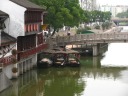A close-up of some boats parked by a (different) bridge.

