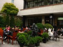 There are a number of stores in the courtyard.  This photo is of a 
coffee-house with many outdoor tables.  Many white people.  I don't 
have anything to say about the strange sculpture.

