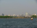 This picture captures four things: Bai Causeway (actually a narrow,
man-made land bridge), the Hangzhou city skyline, a boat, and a kite.
