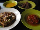 Clockwise from upper-left: gravy, beef rendang (sweet, clove-y), sambal 
fish, and tahu goreng (deep-fried tofu with bean sprouts and cucumbers in 
a peanut sauce).  Everything was good.

