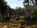 Approaching the Bayon, a temple in the center of Angkor Thom.  Perhaps 
excellent for its artistic ruins (e.g., the scattered stones and the 
columns without roofs).  Also note the statues by the stairs, and the 
towers; we'll be seeing a lot more of these towers.
