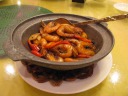 Shrimp in a clay pot with peppers.
