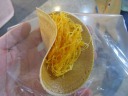 A crispy roti with sweetened string coconut (yellow) and unsweetened 
coconut (white).  Interesting.  Decent I suppose.
