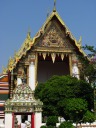 A flowery gateway in front of a gilded hall.
