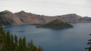 My first view of Crater Lake.  This is a high-resolution picture 
looking north-west.  Notice how tranquil the lake is and how high the 
rim is above the lake. The island is called Wizard Island due to 
its resemblance to a wizard's hat.  My parents complain it looks more 
like a coolie hat / conical Asian hat than a wizard's hat.
