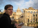 An excellent picture of me by the Roman Forum, with the Temple of 
Saturn in the foreground and the Santi Luca e Martina church in the 
background.  I like this picture so much I claimed it and as you can see 
uploaded it with my set.  It's typical me: standing in front of an 
amazing site, guidebook in hand.
