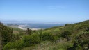 In this high-resolution photo looking east from the park, one sees the 
curve of the Candlestick Park stadium, the bay, and the east bay.  I 
don't know what that large crane is.
