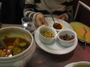 The components of Di Yin's vegetable couscous dish.  One was supposed to 
use couscous (right) as the base on which to ladle the stew (left).  The 
topping (middles) of a spicy sauce, garbanzo beans, and raisins were 
optional.  The stew was mainly made from marrow, a zucchini-like squash 
whose distinguishing feature is that the meat is a bit stringy in the 
same style as winter squashes (but less prominently so).  It also had 
carrots and potatoes.  Naturally, the stew based tasted very squashy-y.  
I thought this dish was decent/good.  Di Yin said it was great, and 
planned to make something similar at home (and indeed she later did).
