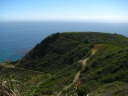 A road/trail leading up to the large mound along the coast.
