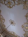 Various musical instruments in gold relief on the music room's ceiling.
