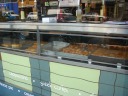 Part of a bakery filled with a splendid expanse of Greek desserts.
