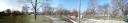 A panorama of Trinity-Bellwoods Park, including paths, a water fountain, 
benches, and athletic fields.
