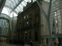 The gallery's so tall, it encloses a bank building's front.
